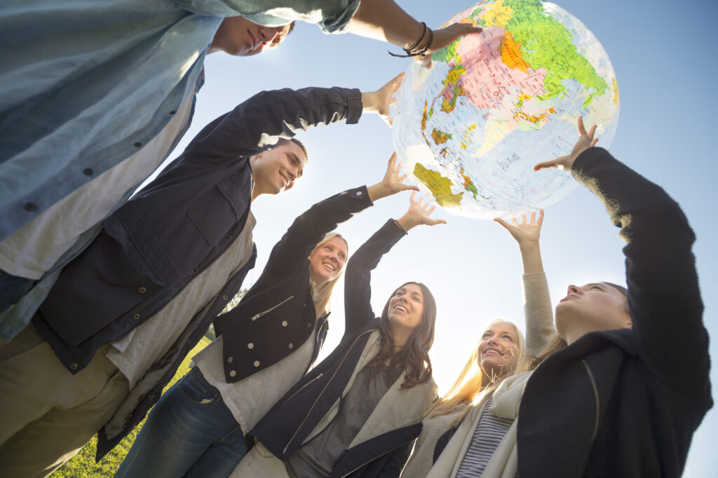 Group of people holding a world globe outdoors